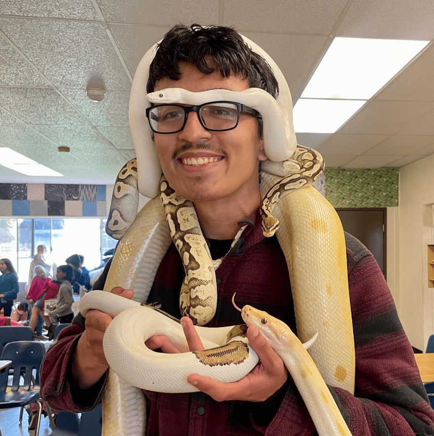 download (2) A man holding two snakes in his hands.
